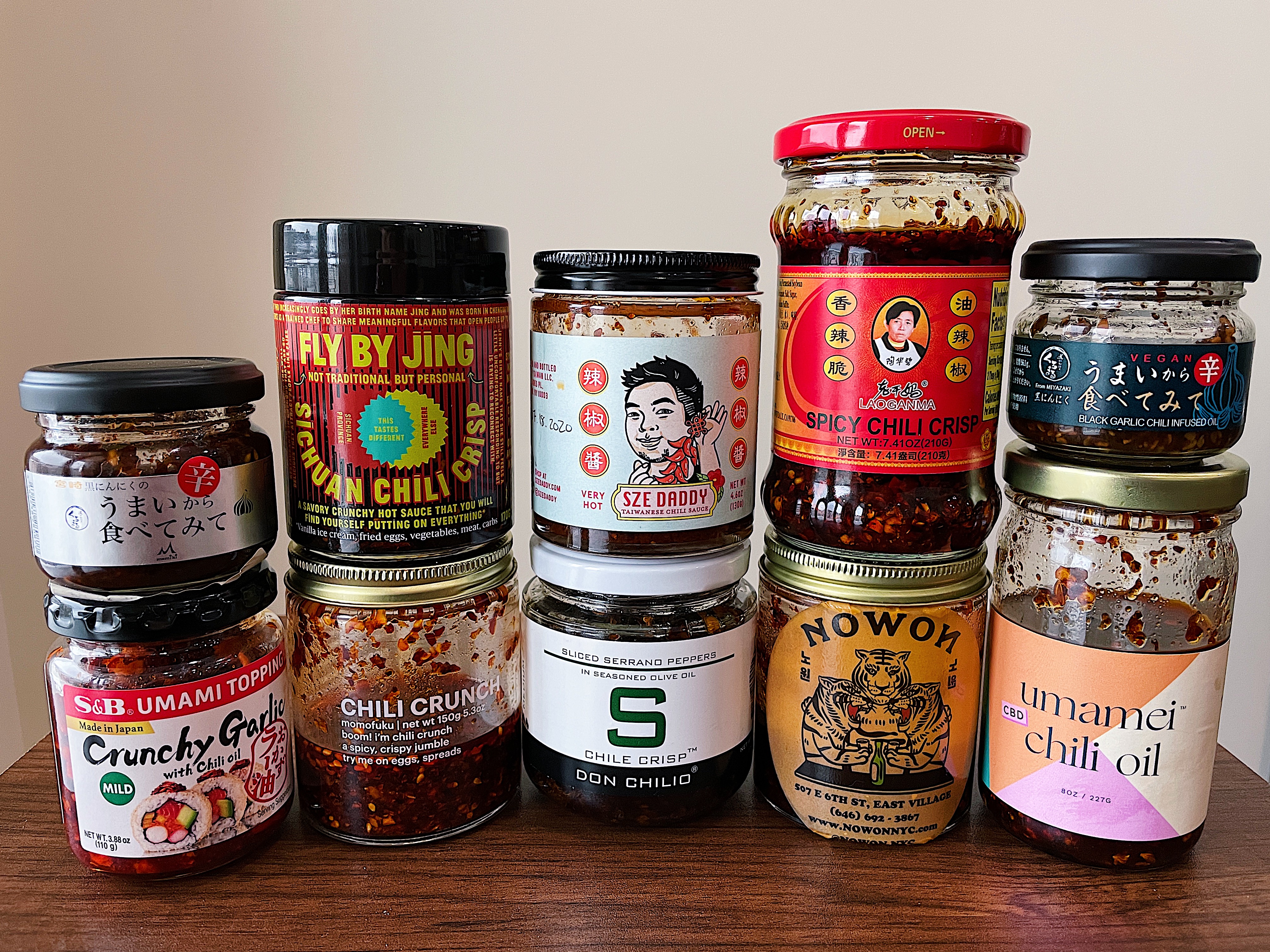 Ten assorted jars of various different chile crisp brands.
